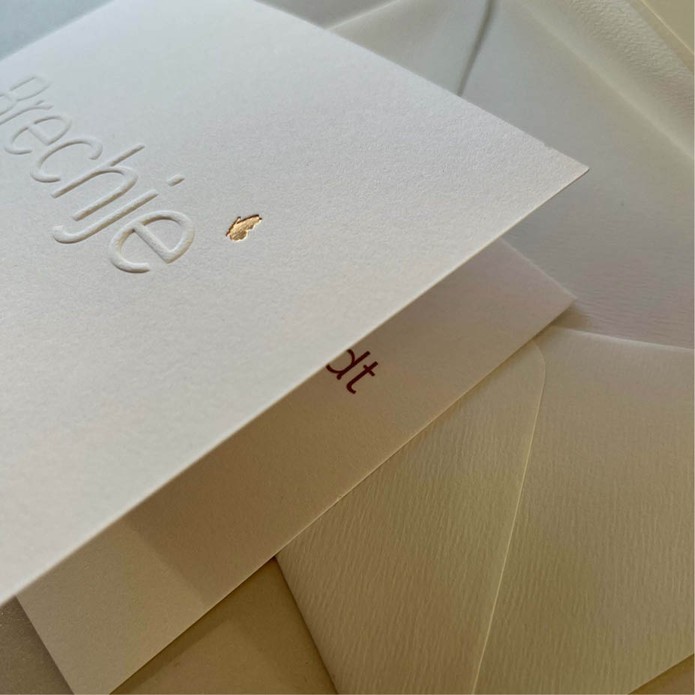 Minimalistisch geboortekaartje met reliëfdruk en goudfolie vlinder