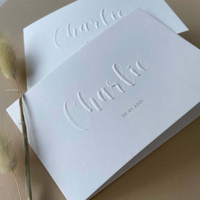 Gevouwen unisex geboortekaartje met naam in reliëfdruk verhoogd