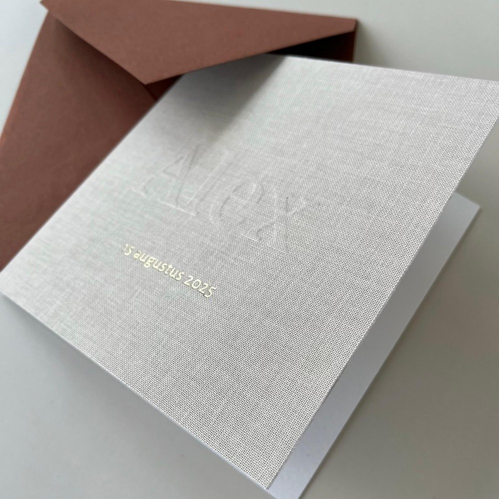 Gevouwen linnen geboortekaartje met subtiele reliëfdruk