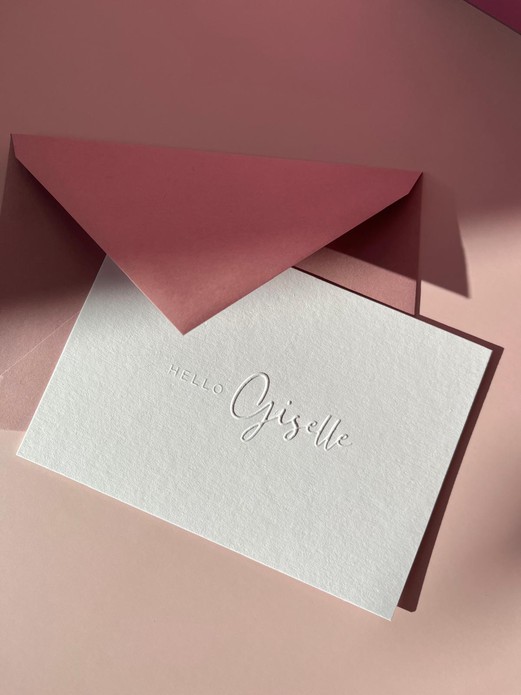 Wit minimalistisch geboortekaartje met de naam in reliëfdruk