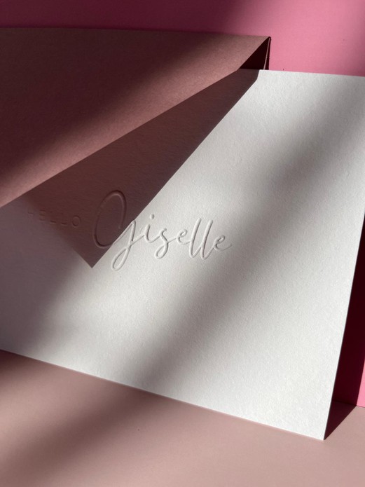 Wit minimalistisch geboortekaartje met de naam in reliëfdruk