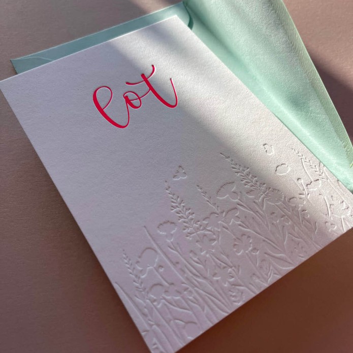 Romantisch geboortekaartje met bloemen veld in blinde druk en sierlijke naam van roze folie