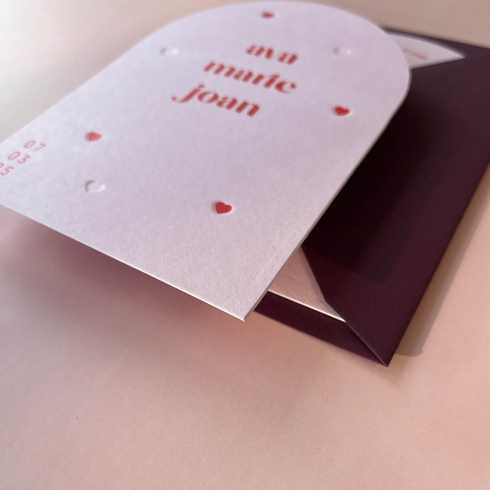 Geboortekaartje in boogvorm, lichtroze met hartjes van reliëf